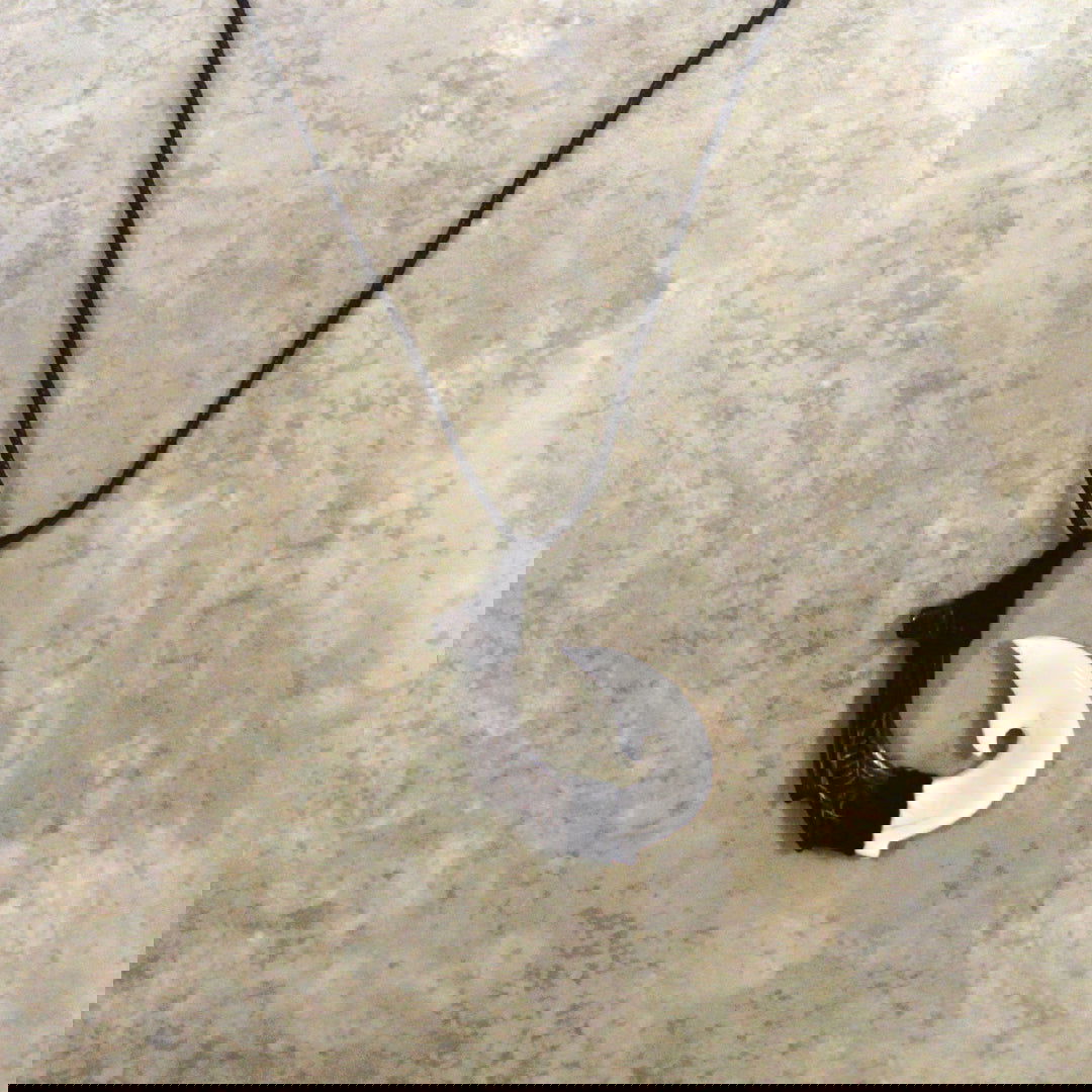 Adjustable necklace featuring a carved black wood and bone hook design, showcasing intricate craftsmanship and a stylish, natural aesthetic.