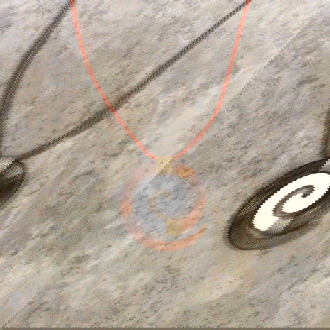 Adjustable necklace featuring a brown wood and bone design with a Koru motif, symbolizing new beginnings and growth, perfect for adding a touch of nature-inspired elegance.