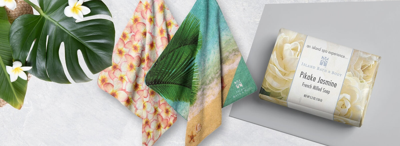 Banner with tropical plants and flowers Pikake Jasmine wrapped bar of soap. Hawaii plumeria and beach hand towels.