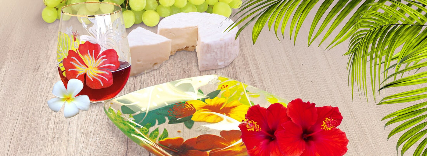 Banner with tropical plants and flowers with green grapes, white cheese a Hawaii floral painted glass and plate.
