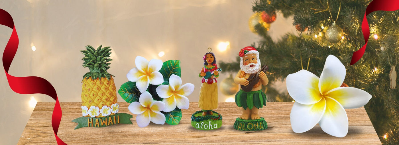 Banner with Hawaii ornaments on table with Christmas tree and ribbon. Pineapple, plumerias, hula ukulele, santa ukulele.