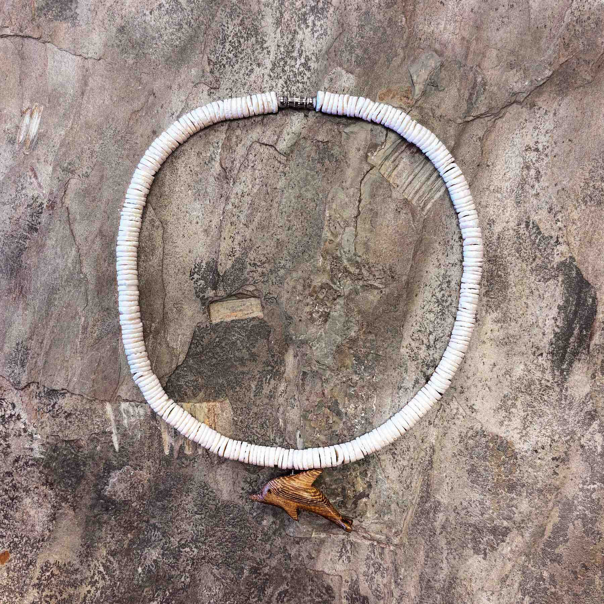 Hawaiian-style necklace with white clam shells and handcrafted wooden dolphin charm