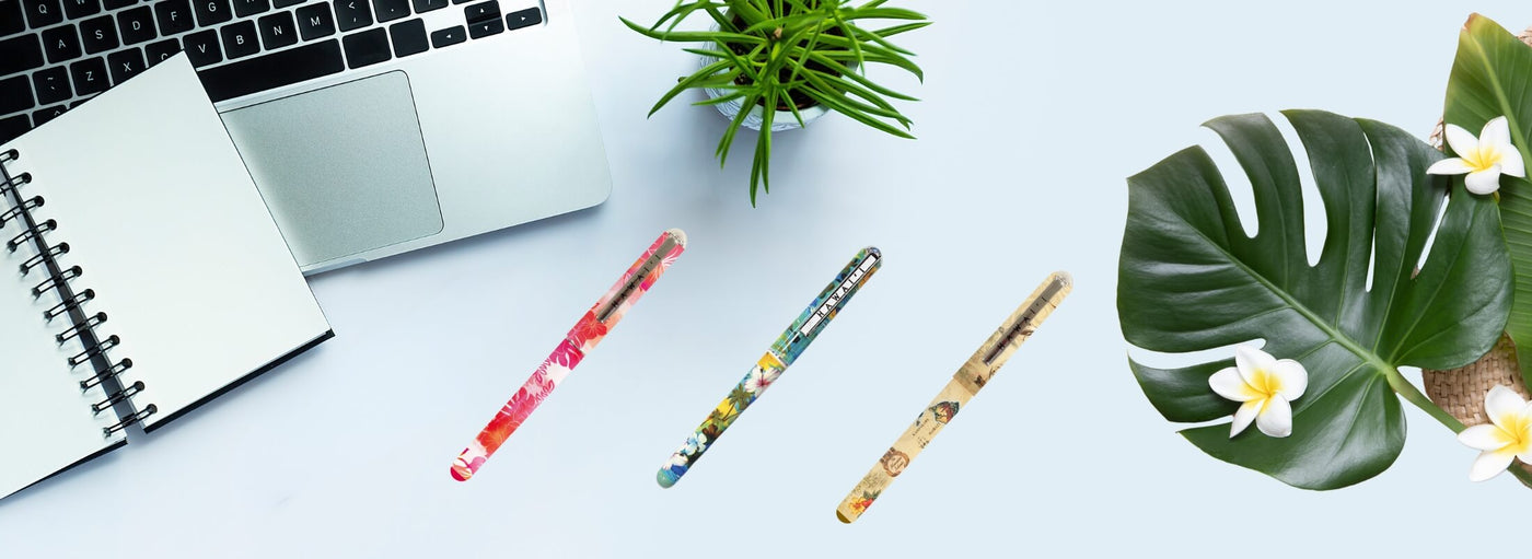 Banner with laptop open note pad, tropical flowers and three Hawaii pens.