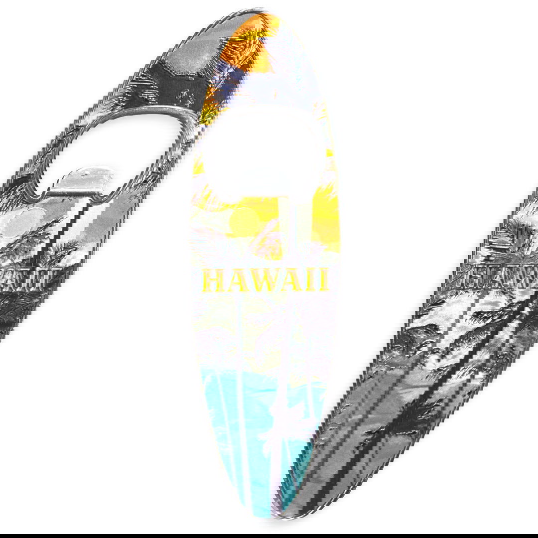 Magnetic bottle opener in the shape of a surfboard, showcasing a palm tree silhouette against a vibrant sunset backdrop.