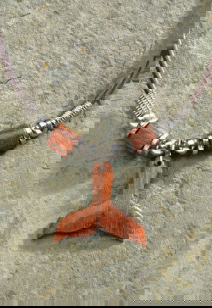 Rubber cord necklace featuring a wooden whale tail pendant, showcasing a stylish design inspired by marine life and tropical themes.