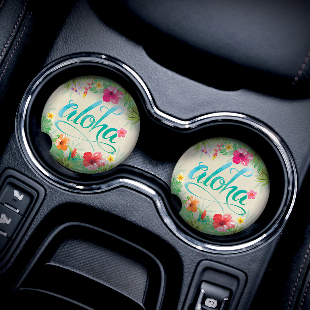 Lifestyle image of two aloha floral car accessories in car cupholders.