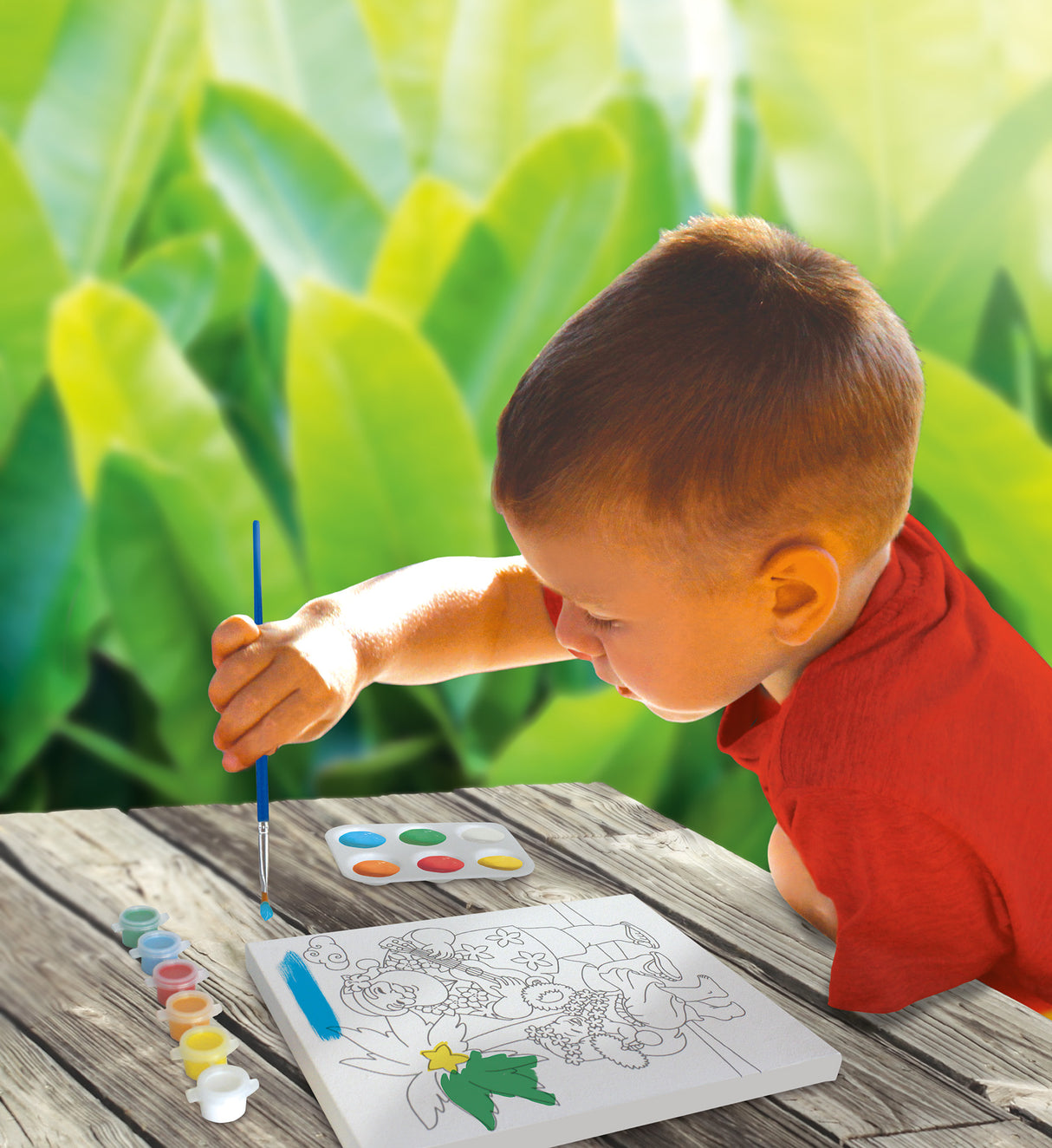 A lifestyle photo of a young boy using the paint kit.
