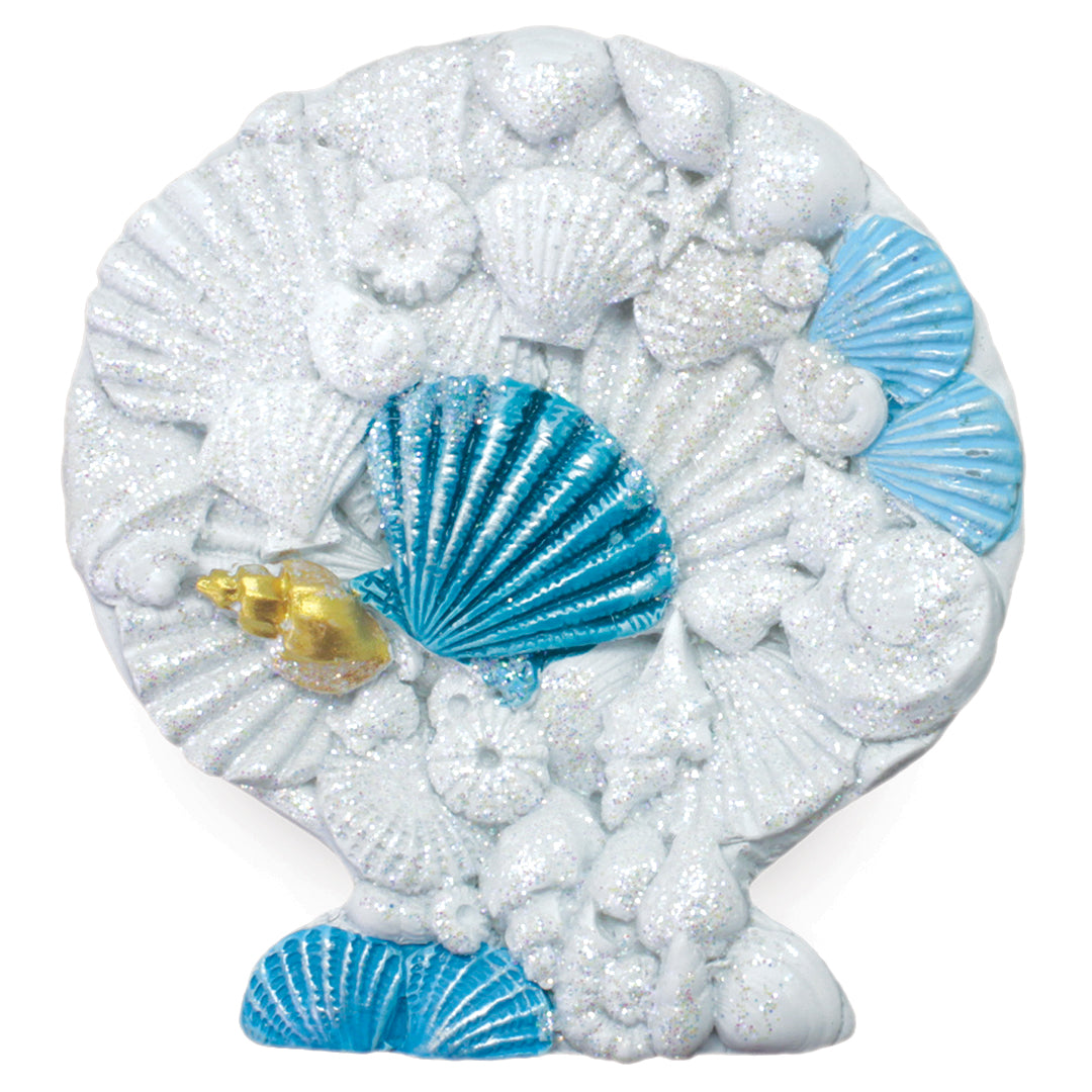 A decorative seashell-shaped magnet covered in glittery white seashell and starfish motifs, with bright blue shell accents and a small gold shell detail, shown on a plain white background.