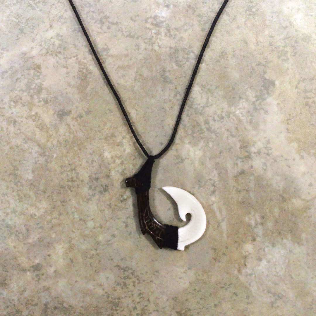 Adjustable necklace featuring a carved black wood and bone hook design, showcasing intricate craftsmanship and a stylish, natural aesthetic.