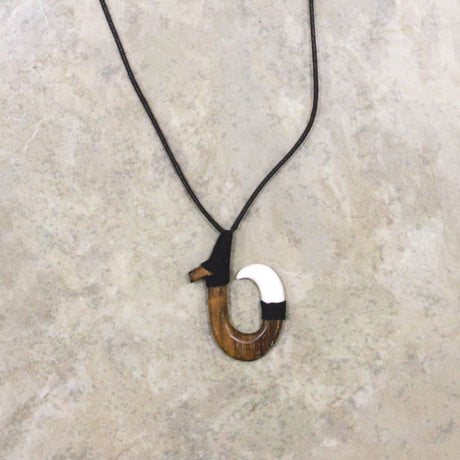 Adjustable necklace featuring a black wood and bone hook design, offering a stylish and contemporary look inspired by natural elements.