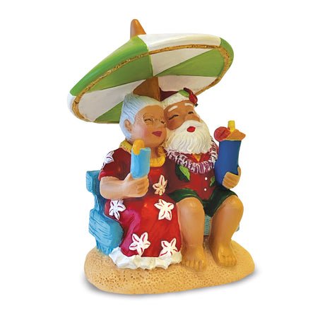 Colorful figurine of Santa and Mrs. Clause under an umbrella on a white background