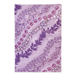 Purple lei floral patterned kitchen towel on a white background