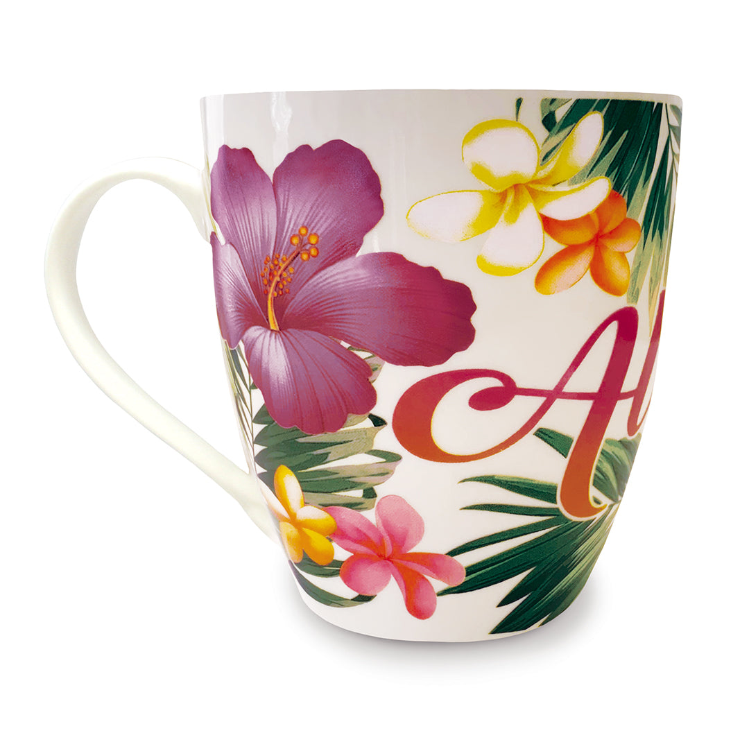Side view of a white Hawaii mug with the word aloha and some flowers and tropical leaves.