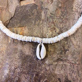 Island-style necklace featuring cowrie shell and white clam accents on a natural cord