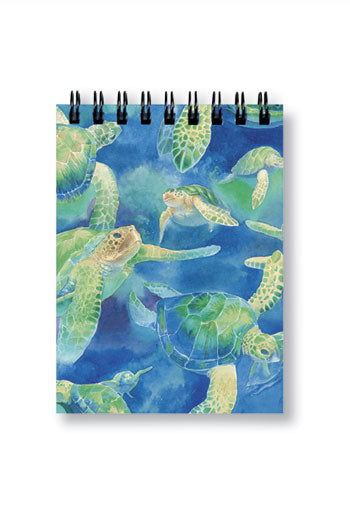 Small notebook featuring a swimming honu (sea turtle) design on the cover, adorned with vibrant colors and ocean-themed elements, ideal for jotting down notes and ideas.