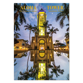 Aloha Tower with palm trees and reflection in water at dusk