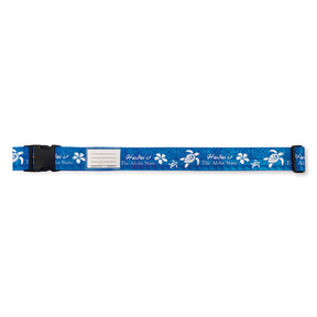 Aloha Honu luggage strap in blue, 71”L x 2”W, featuring durable polyester construction, an adjustable buckle, and a blank ID card for secure travel.