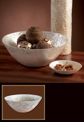 Decorative bowl with textured surface on a wooden surface, with smaller bowl and decorative items in the foreground.