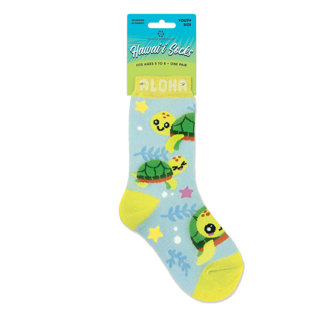 Children's sock with turtle design on a blue background, featuring 'Hawaii Socks' packaging.