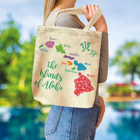 Person holding a tote bag with 'Islands of Aloha' design featuring Hawaiian islands and turtles.