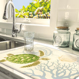 A lifestyle photo of a Kitchen drying mat with a Hawaiian sea turtle, coral and shells