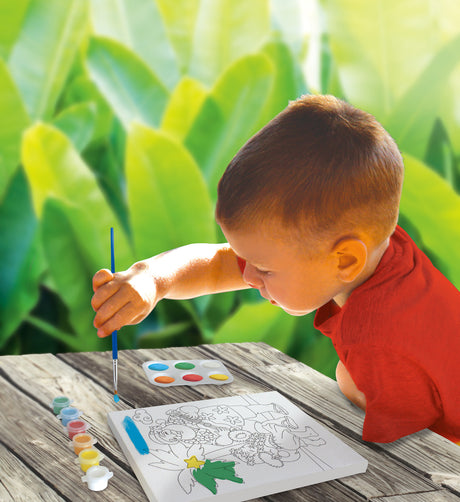 A lifestyle photo of a young boy using the paint kit.