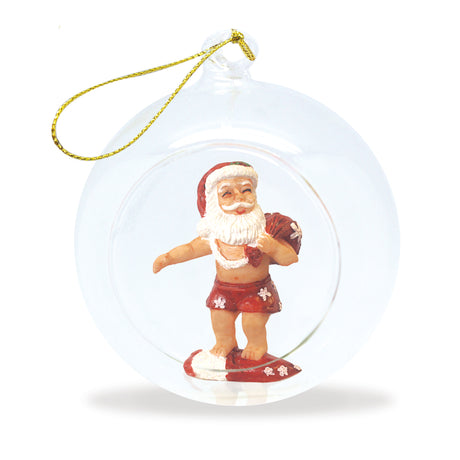Glass Christmas ornament with Santa Claus in swim trunks and a surfboard.